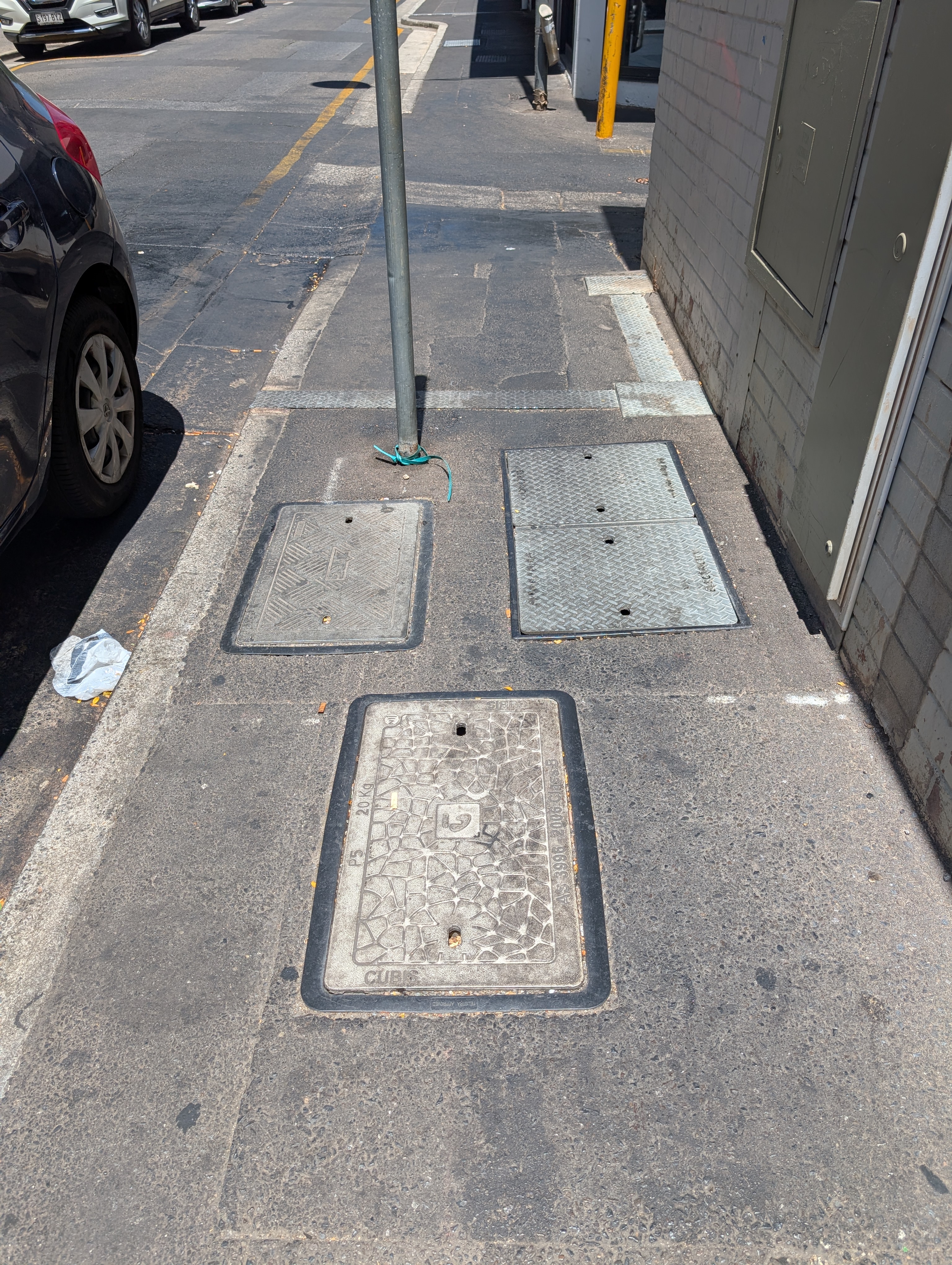 NFC-enabled telecommunications access cover installed in a footpath